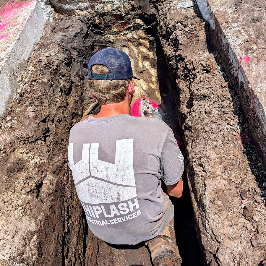 A Whiplash Industrial Services crew member working in a trench