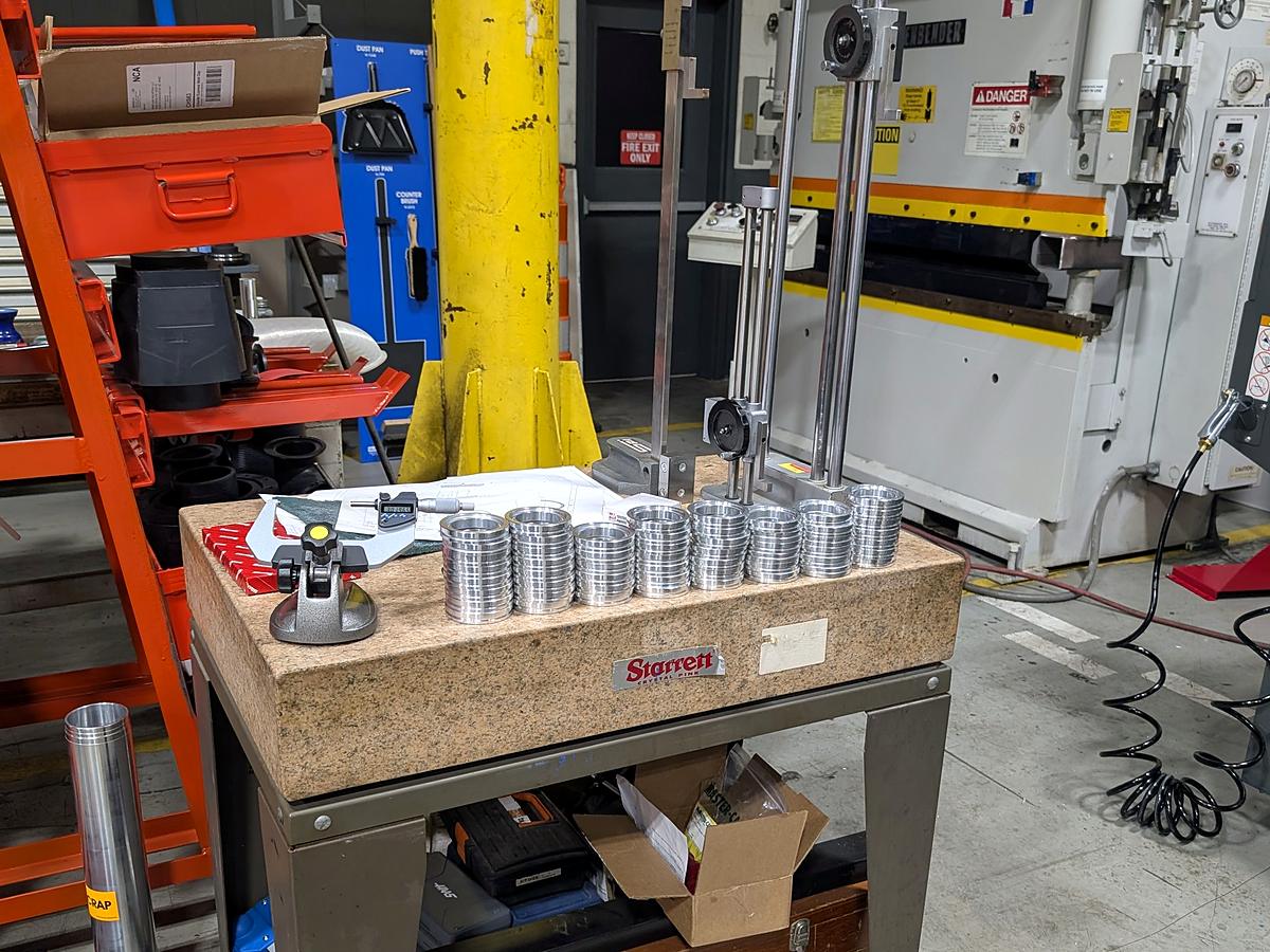 Machined parts checked with a height gauge on a granite surface plate