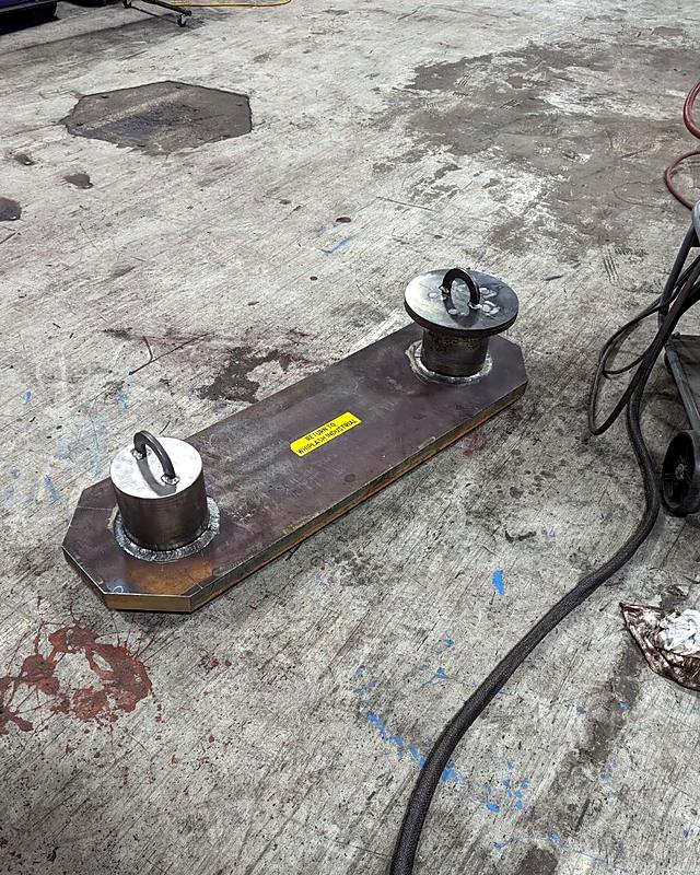 A heavy plate fixture with two lifting pins, labelled Return to Whiplash Industrial