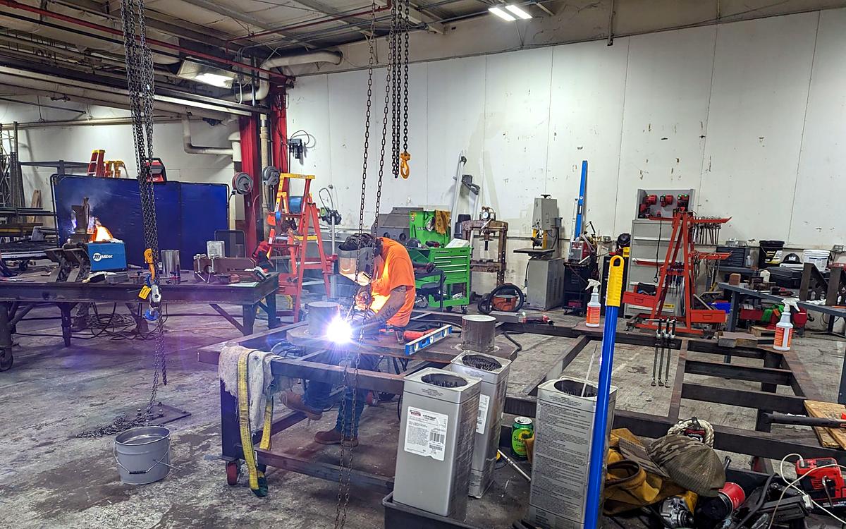 The shop floor, with welding underway at the tables